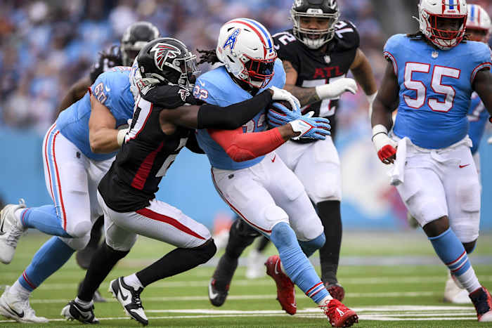 Tennessee Titans running back Derrick Henry (22) runs as Atlanta Falcons safety Richie Grant (27) gets dragged during the first half at Nissan Stadium.
